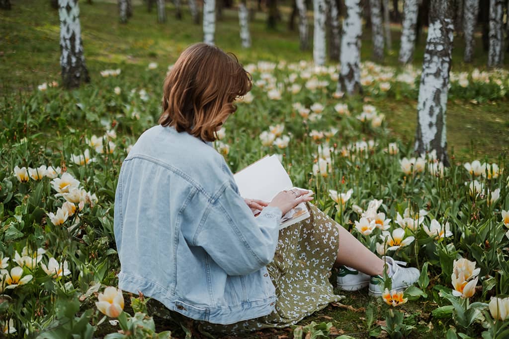 Digital Garden - Femme entrepreneure au milieu d'un jardin, en train de feuilleter un livre